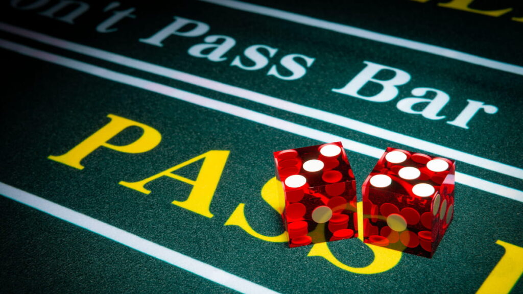 Two red dice on the Pass Line section of a craps table.