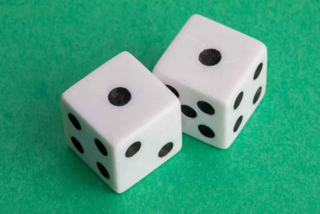 A pair of dice showing ones against a green background.